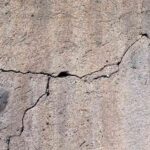 Mur en béton avec fissures profondes et surface rugueuse
