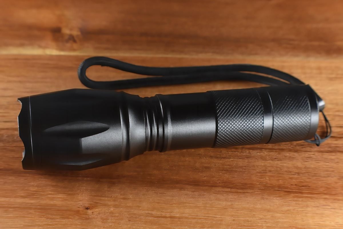 Lampe torche noire sur un bois clair Lampe torche noire sur un bois clair